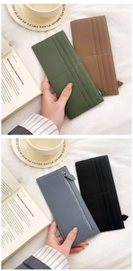 Detail of lychee leather card wallets in multiple colors with metal zippers on fabric