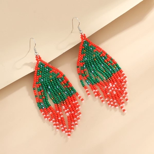 Detail of bohemian handmade beaded tassel earrings in festive red and green colors