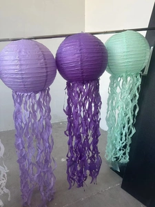 Three-piece jellyfish paper lanterns in purple and mint green with wavy fringe tassels