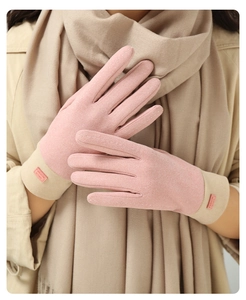Detail of pink faux suede touchscreen gloves with beige knit cuffs and fashion label