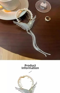 Detailed close-up of butterfly wing hair claw clip with rhinestones and long tassel chains