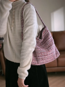 Gros plan sur la texture du sac à bandoulière en tweed tissé rose et violet élégant