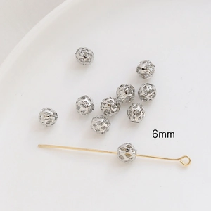 Detail of 6mm silver hollow spherical beads for DIY jewelry making on white background