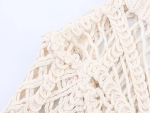 Detail shot of ivory crochet texture showing intricate hollow knit pattern and cotton fibers
