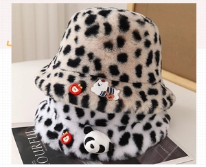 Detail of plush animal print bucket hats featuring leopard, cow patterns and cute patches