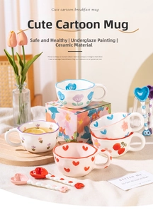 Close-up of ceramic mug set with hand-painted tulip patterns and heart handle spoon