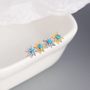 Dettaglio macro di orecchini a stella in argento S925 e oro 18K con opali blu
