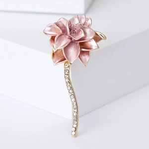 Detail of pink enamel lotus brooch with sparkling crystals and golden stem