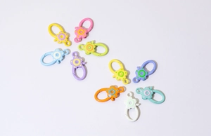 Close-up of colorful flower-shaped alloy spring ring hooks for DIY keychain jewelry