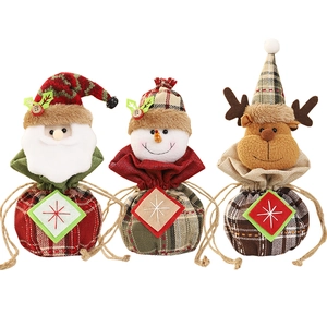Three Christmas drawstring gift bags featuring Santa, snowman, and reindeer designs