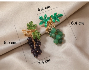 Detail view of purple and green grape brooches with size measurements in centimeters