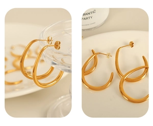 Macro detail of thick gold C-shaped teardrop earrings with a glossy metallic finish