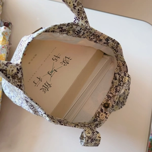 Detail view of floral cotton tote bag showing inner storage capacity with books