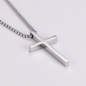 Macro shot of silver stainless steel cross pendant featuring a polished finish and box chain