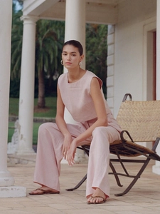 Detail eines rosa Leinen-Zweiteilers mit ärmellosem Crop-Top und Hose mit weitem Bein