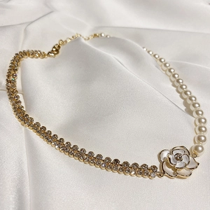 Détail du pendentif camélia avec brins de perles et doubles chaînes en strass