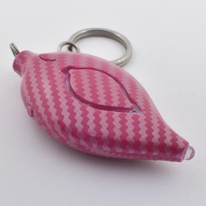 Close-up of pink leaf-shaped personal alarm with textured surface and metal keychain