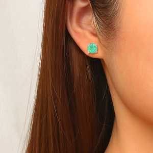 6mm green resin opal stud earrings with 4-claw silver setting shown on a model