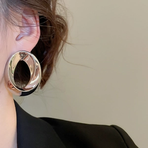 Close-up of polished silver double hoop earrings with a geometric layered design