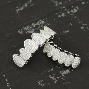 Iced out silver hip hop grillz set with zircon stones on a dark textured background