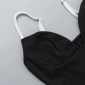 Detalle de tirantes en contraste con hebillas metálicas en mini vestido negro con cuello en V