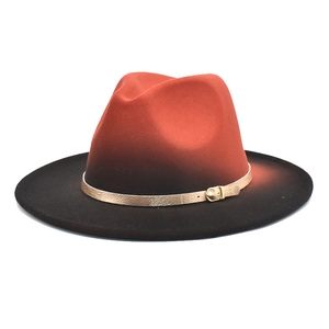 Detail of red and black gradient wool fedora with a gold buckle decorative band