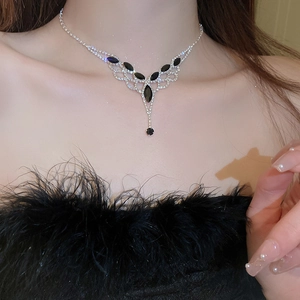 Detail of silver tassel necklace with black marquise stones worn by a model