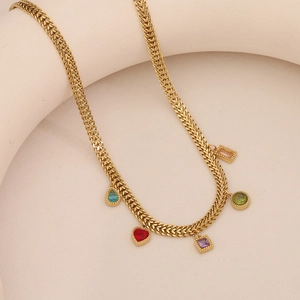 Macro detail of gold necklace featuring colorful heart and shell pendants with gems