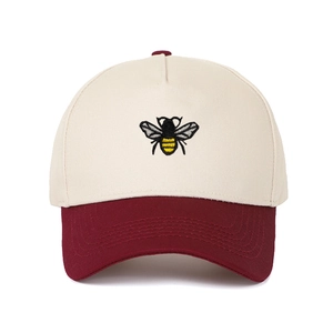 Close-up of detailed bee embroidery on ivory and burgundy two-tone cotton baseball cap