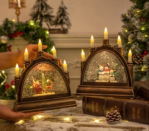 Detail view of a bronze Christmas arch lamp with five LED candles and a festive snow globe