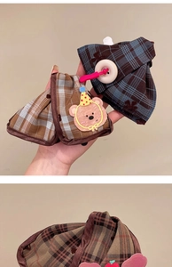 Close-up of cute checkered fabric hair claw clips with bear and button details
