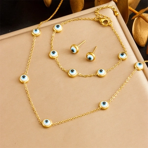 Golden Evil Eye jewelry set featuring necklace, bracelet and earrings on a gift box