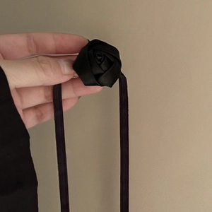 Detailed view of handmade black satin rose pendant with soft silk cord necklace
