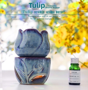 Close-up of a blue tulip ceramic oil burner with a 10ml essential oil bottle