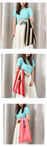 Detail view of colorful striped knit tote bags in black, red, and orange palettes