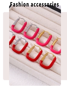 Vue macro de boucles d'oreilles en acier doré en forme de U en émail rose et rouge