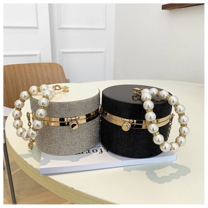 Detail of round rhinestone evening bags with large pearl handles in silver and black colors