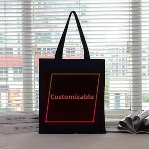 Vertical rectangular black canvas tote bag shown in a lifestyle window setting