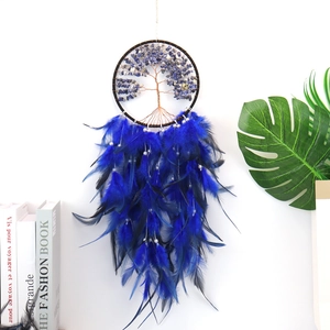 Detail of tree of life dreamcatcher featuring blue feathers and crystal stones