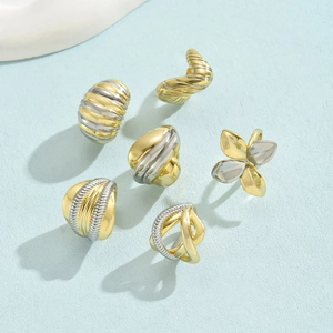 Detail of 18K gold and silver two-tone rings with floral and twisted organic designs
