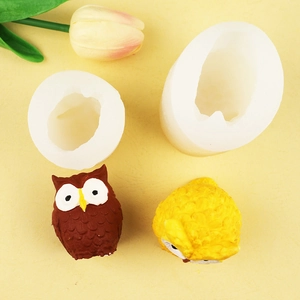 Detailed overhead view of 3D owl silicone mold and finished clay ornaments with feather textures