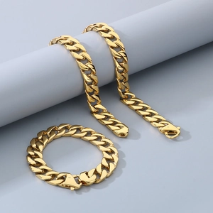 Detailed view of 15mm gold Cuban link chain set including necklace and bracelet on gray stand