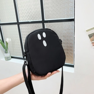 Détail d'un sac bandoulière noir motif fantôme avec sangle en nylon réglable