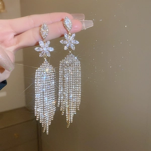 Macro shot of sparkling flower tassel earrings with zircons and starburst light effects