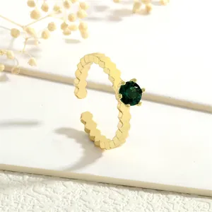 Macro detail of 18K gold wave ring featuring a brilliant green zircon in prong setting