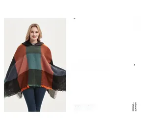 Detailed view of color-block plaid knit poncho with fringe edges and soft texture