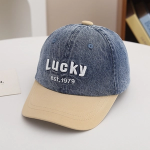 Detail of vintage washed denim kids cap with lucky embroidery and contrast brim