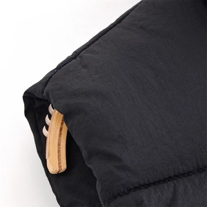 Close-up of black padded vest fabric texture showing soft synthetic fiber details