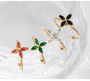 Detailed view of colorful zircon clover rings and ear cuffs in 18k gold plating