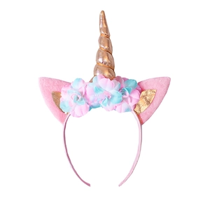 Detailed view of unicorn headband with gold spiral horn and colorful fabric flowers